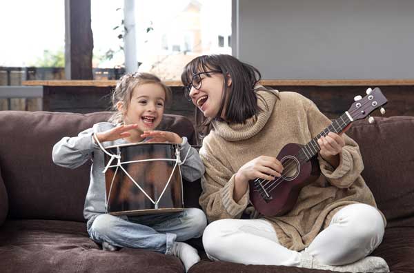 Regalos musicales para niños y bebes. Madre e hija tocando instrumentos infantiles
