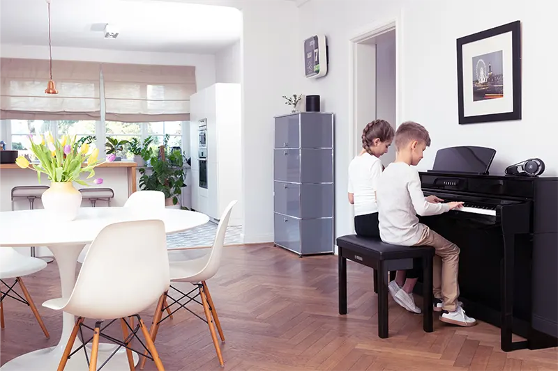 Niños hermanos tocando piano CLP 735 en casa