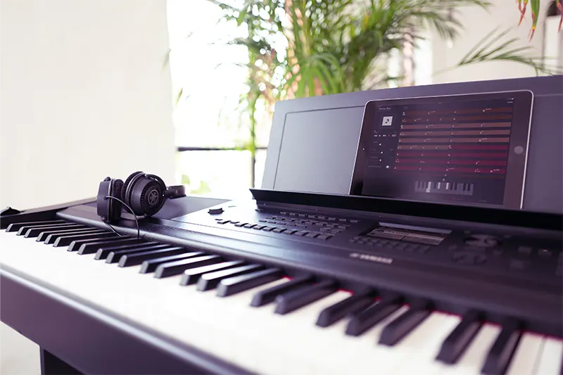 Tablet y auriculares sobre piano DGX 670